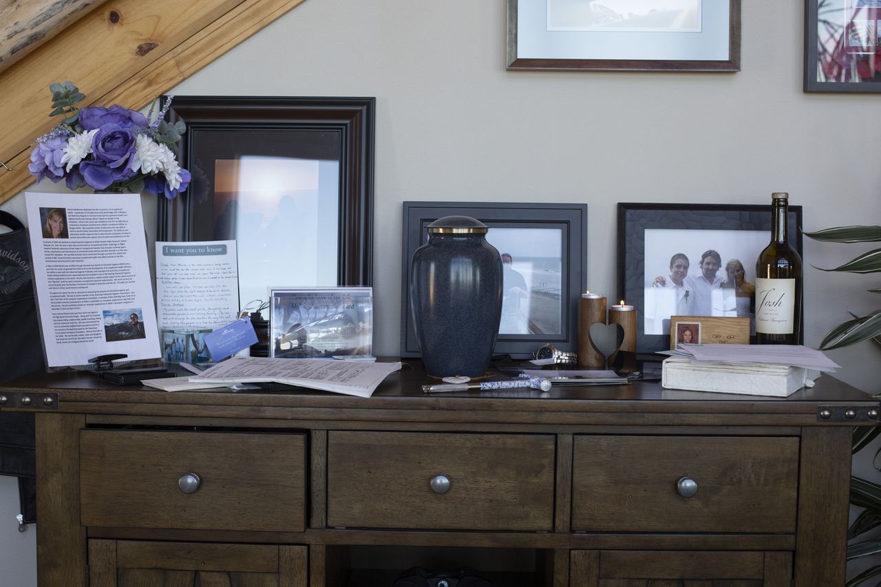 An urn sits on a desk surrounded by keepsakes.