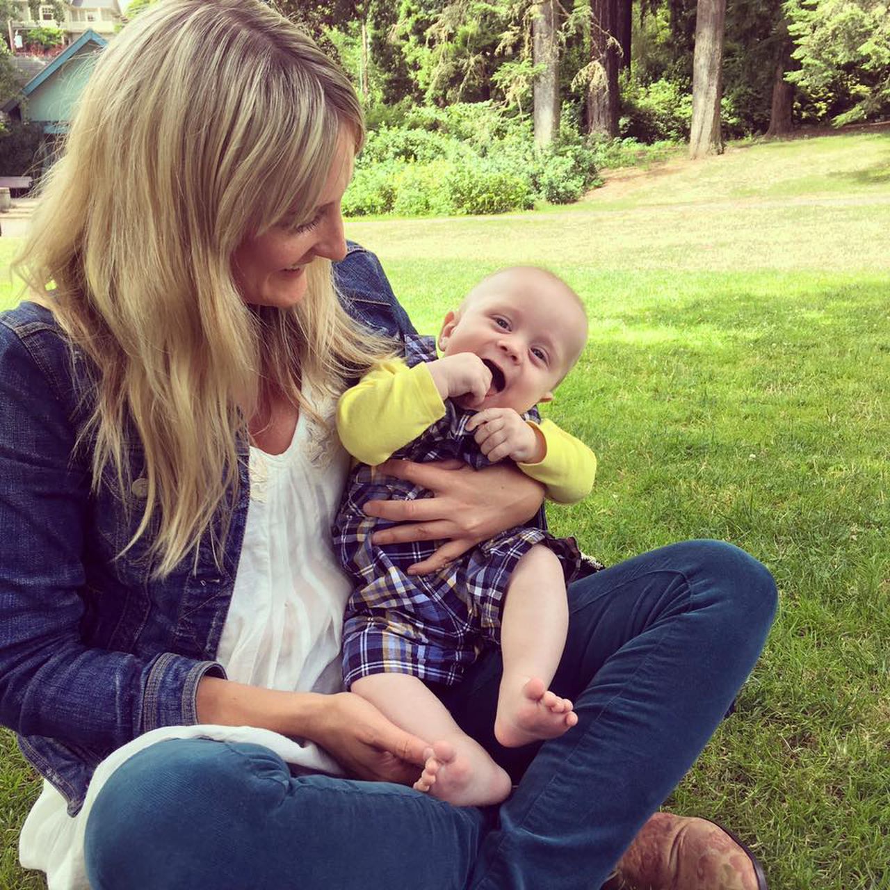 a woman holds a baby in the park