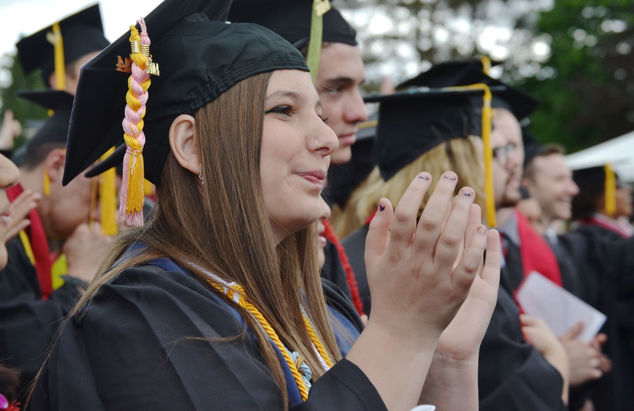 Tiara Herr wearing a graduation cap and gown is shown among fellow graduates