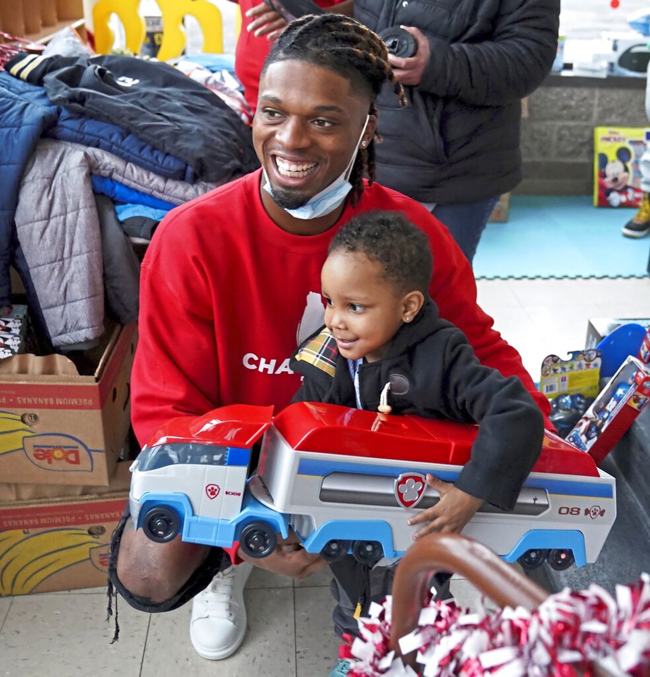 Damar Hamlin poses for a photo with Bryce Williams, 3, of McKees Rocks, Pa., with a toy truck the toddler picked up.